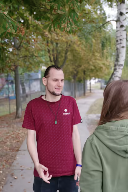 ich, mit zusammengebundenen Haaren, im Gespräch mit einer Person